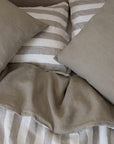 Tess pillowcases on top of a Tess and Stripe reversible linen duvet cover 