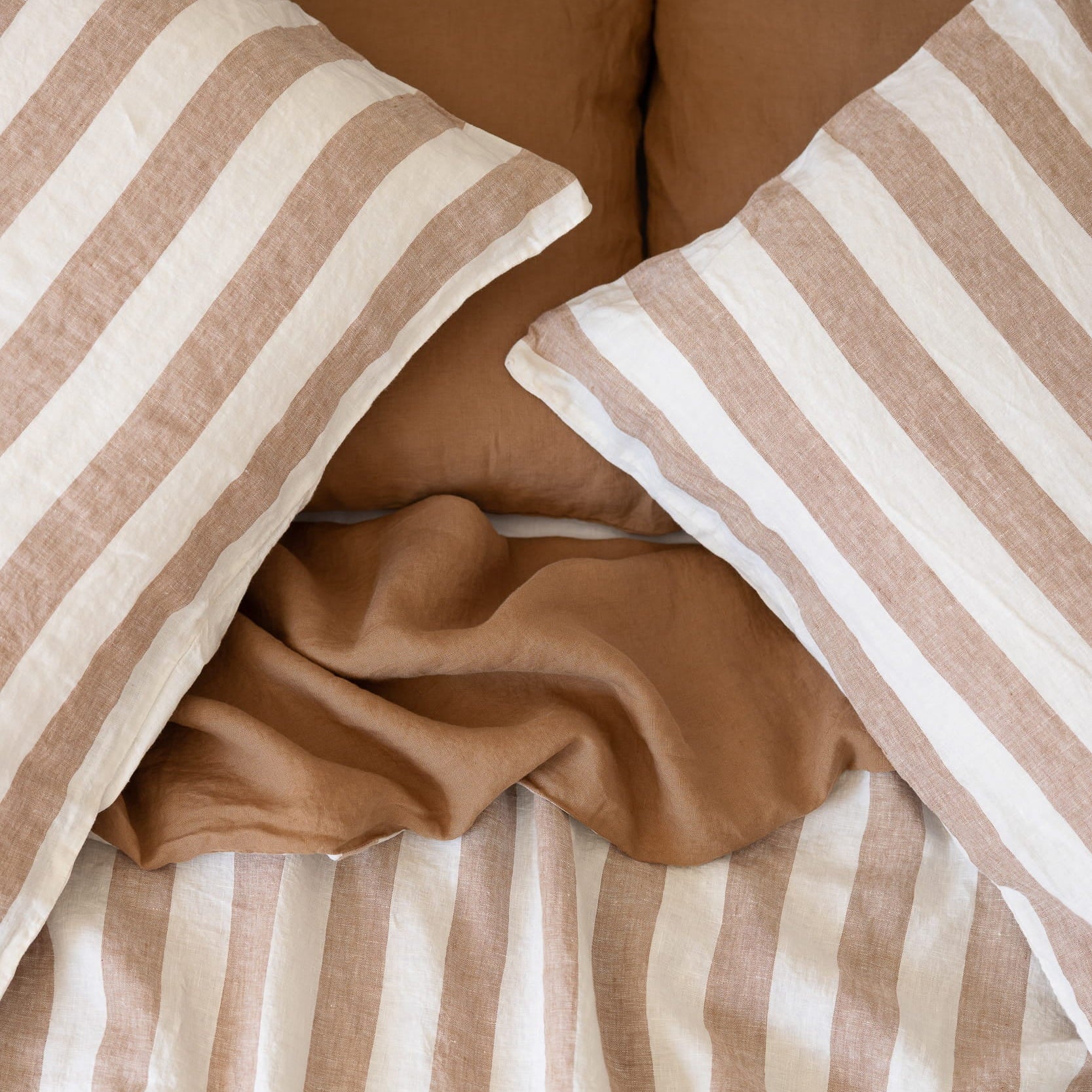 Hazelnut Stripe pillowcases with a Hazelnut and Stripe linen duvet cover underneath 
